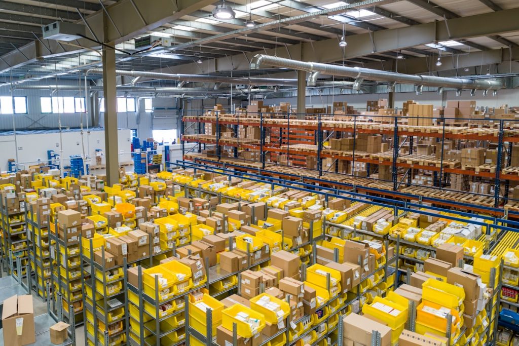 Um grande centro de distribuição logística organizado com paletes e empilhadeiras em operação, simbolizando a excelência no recrutamento de supply chain e finanças.
