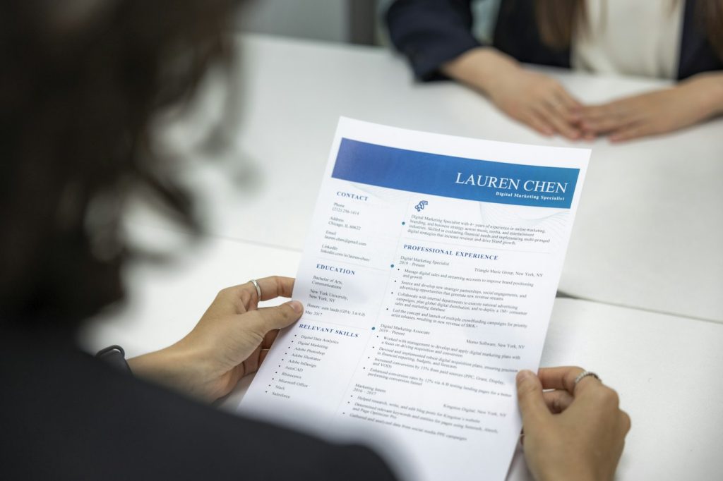 Recrutadora analisando currículo de candidato sobre a mesa